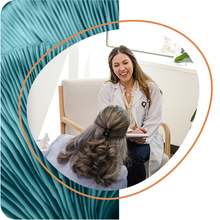 A healthcare provider in a white coat smiles while talking with a patient during a wellness consultation in a bright office